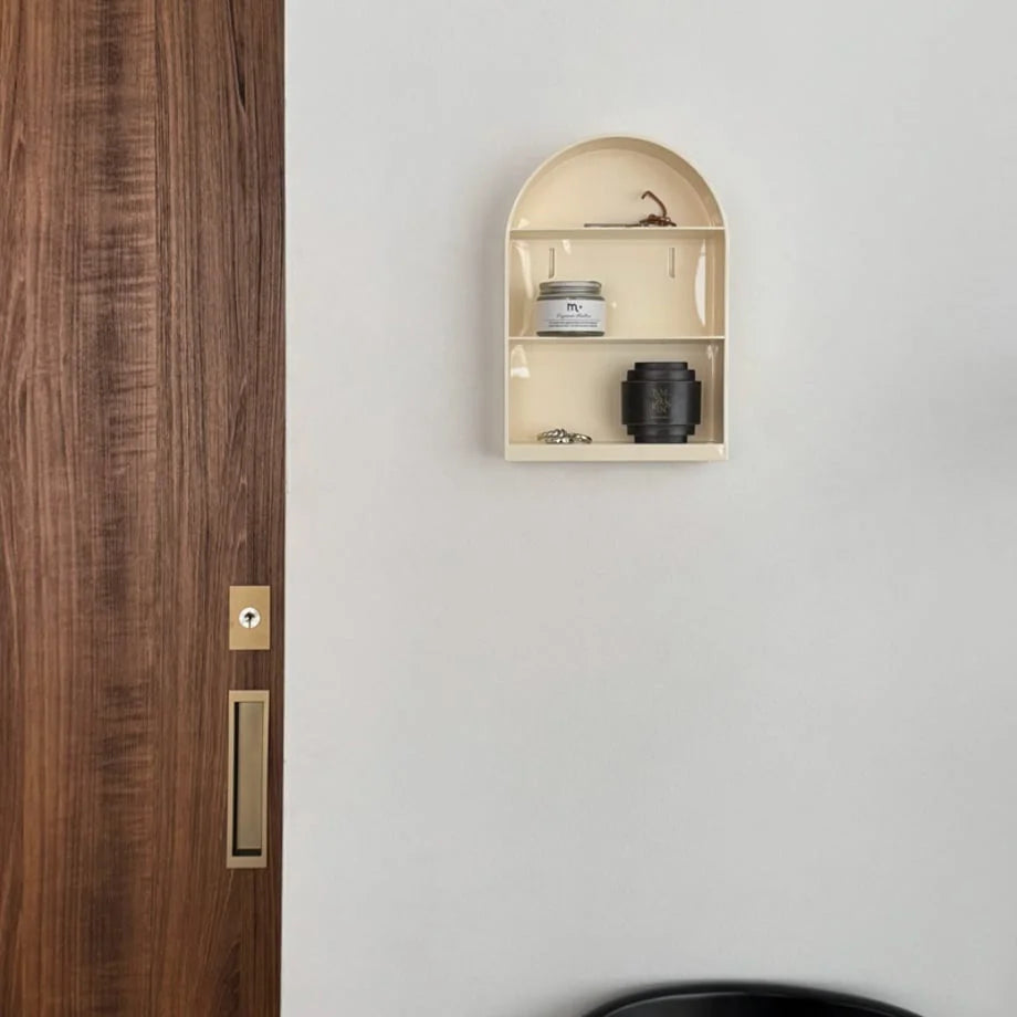 Japandi-style entryway featuring the cream arched wall shelf next to a dark wood door - RoomDen.