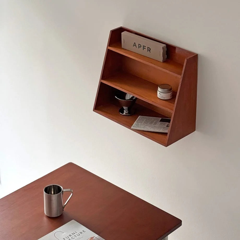 Angled view of the Slanted Wood Wall Shelf displaying a book and candle - RoomDen
