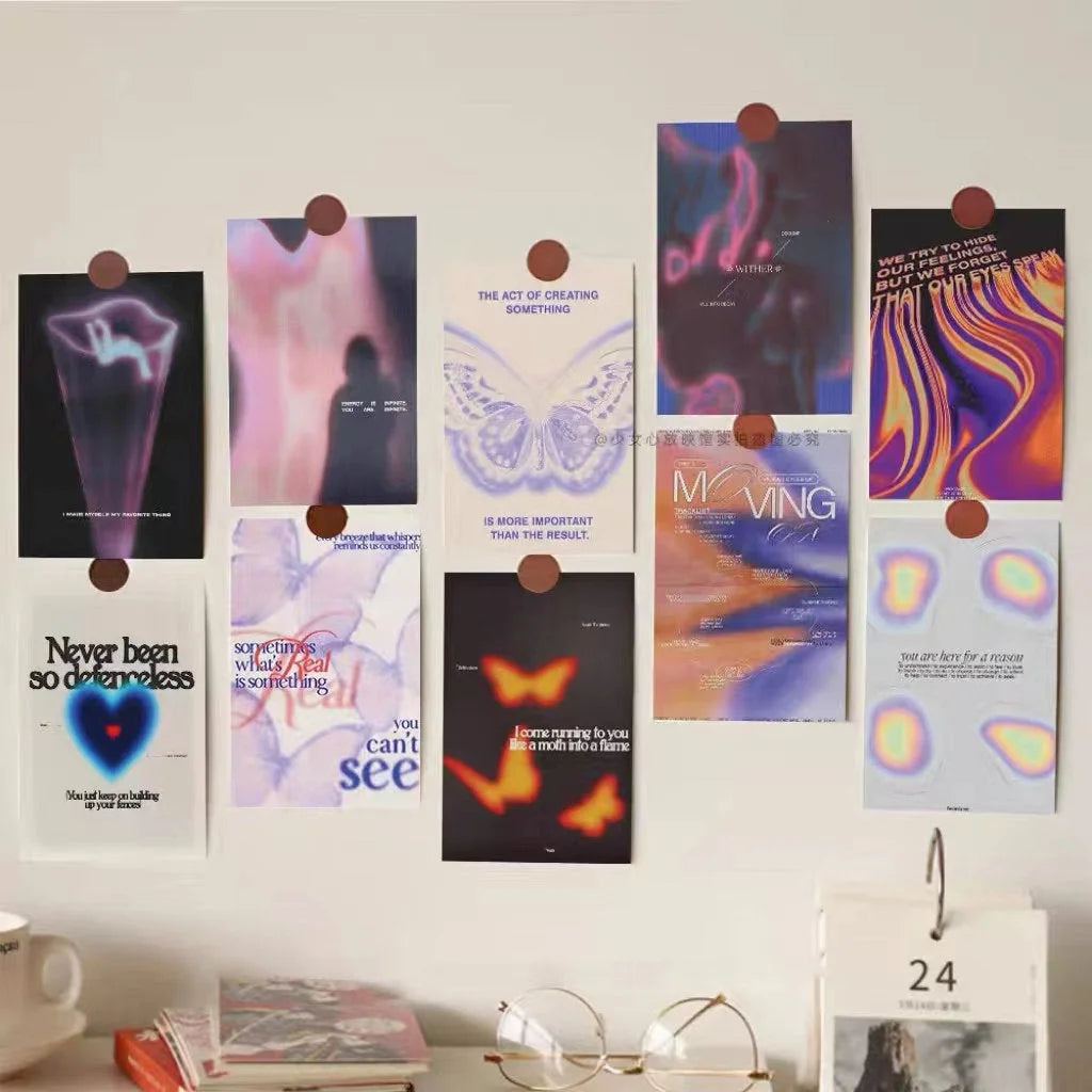 A moody wall collage kit with aura gradient posters arranged on a white wall above a desk. - RoomDen