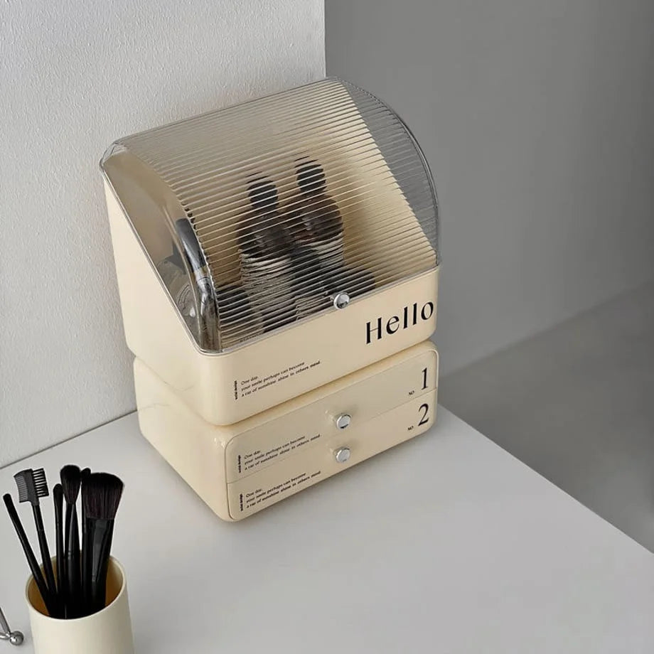 Angled view of the cream typographic makeup organizer, showing the transparent ribbed flip-top lid.