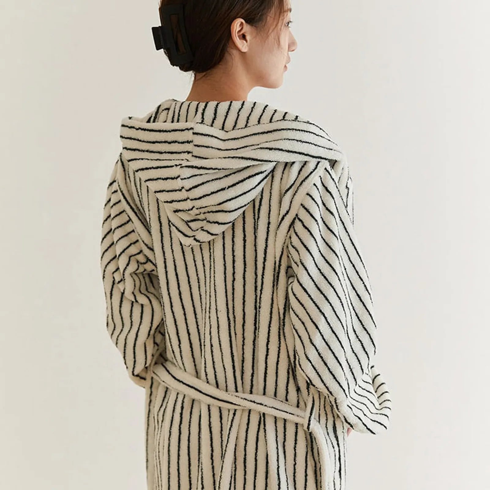 Back view of a woman wearing the hooded striped robe, highlighting the hood design and vertical lines.
