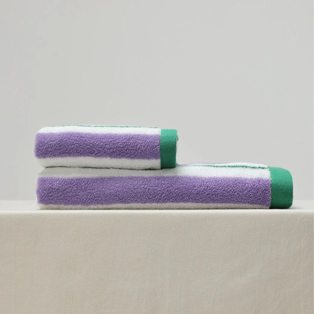 Two folded striped cotton towels, one face towel and one bath towel, stacked on a neutral surface - RoomDen.