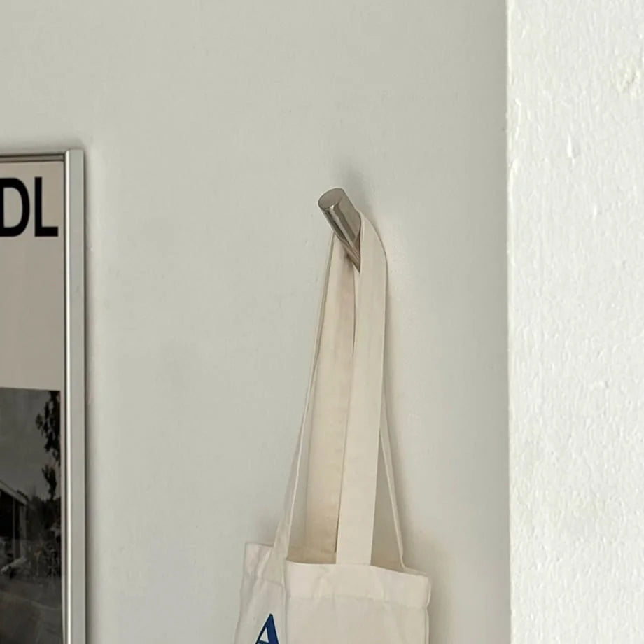 Angled view showing the modern metal wall hook securely holding a tote bag, highlighting its clean lines. - RoomDen