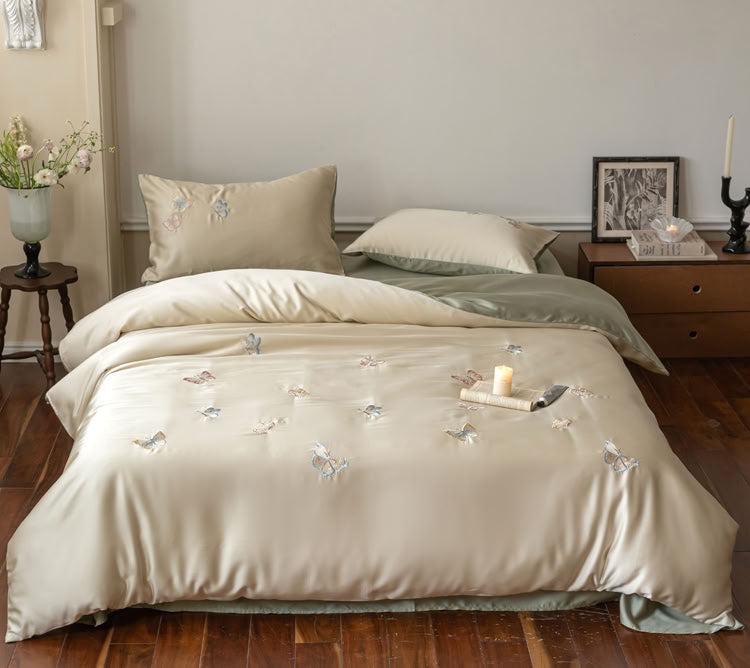 Beige green butterfly embroidered Tencel duvet and pillows in serene bedroom setup - RoomDen