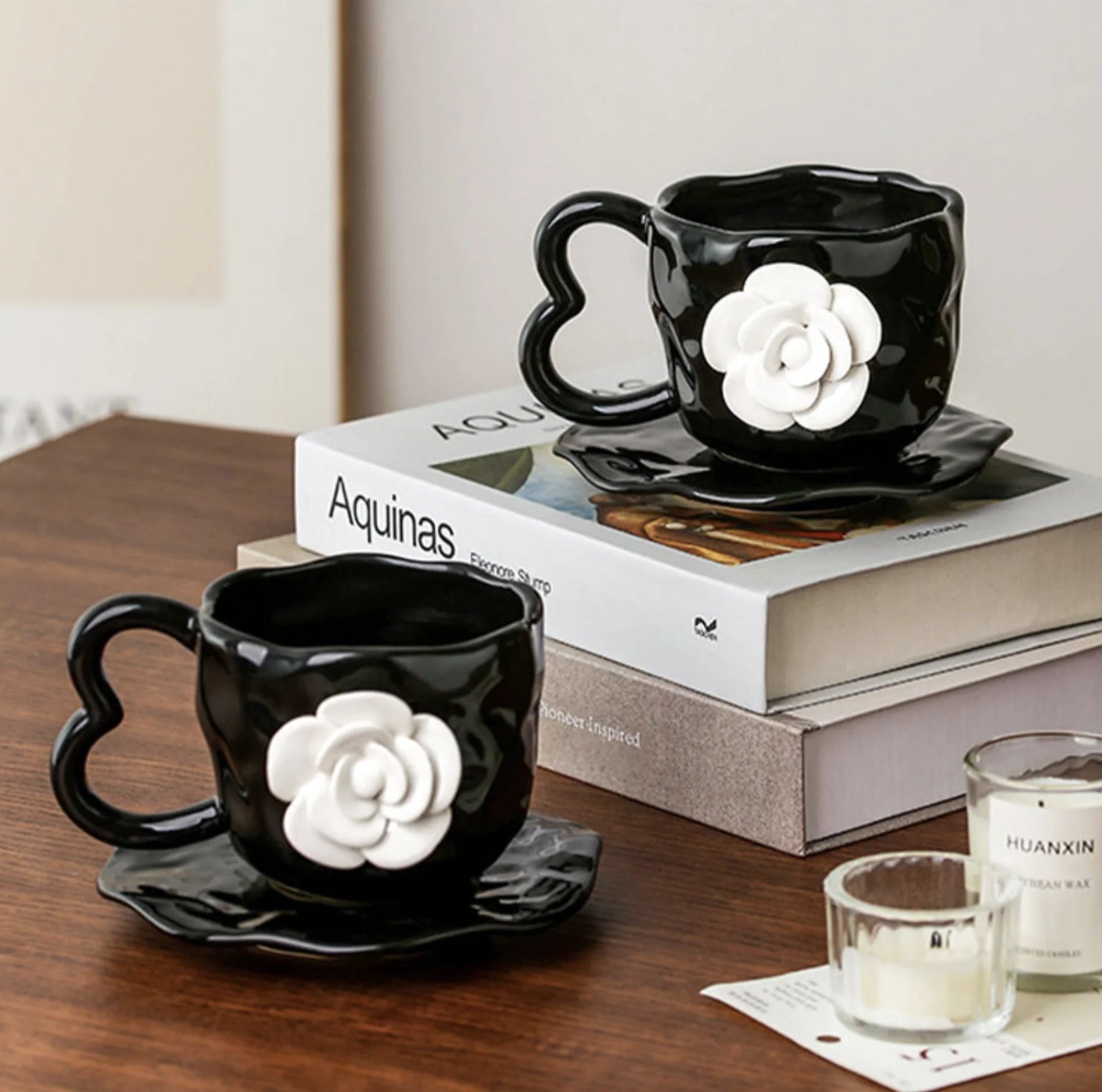 Textured Black Camellia Floral Mug and Saucer Set on a stack of books - RoomDen