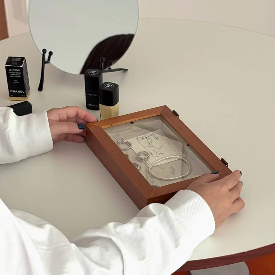 A woman holding a glass lid wood jewelry box, showing the rings and bracelets inside. - RoomDen