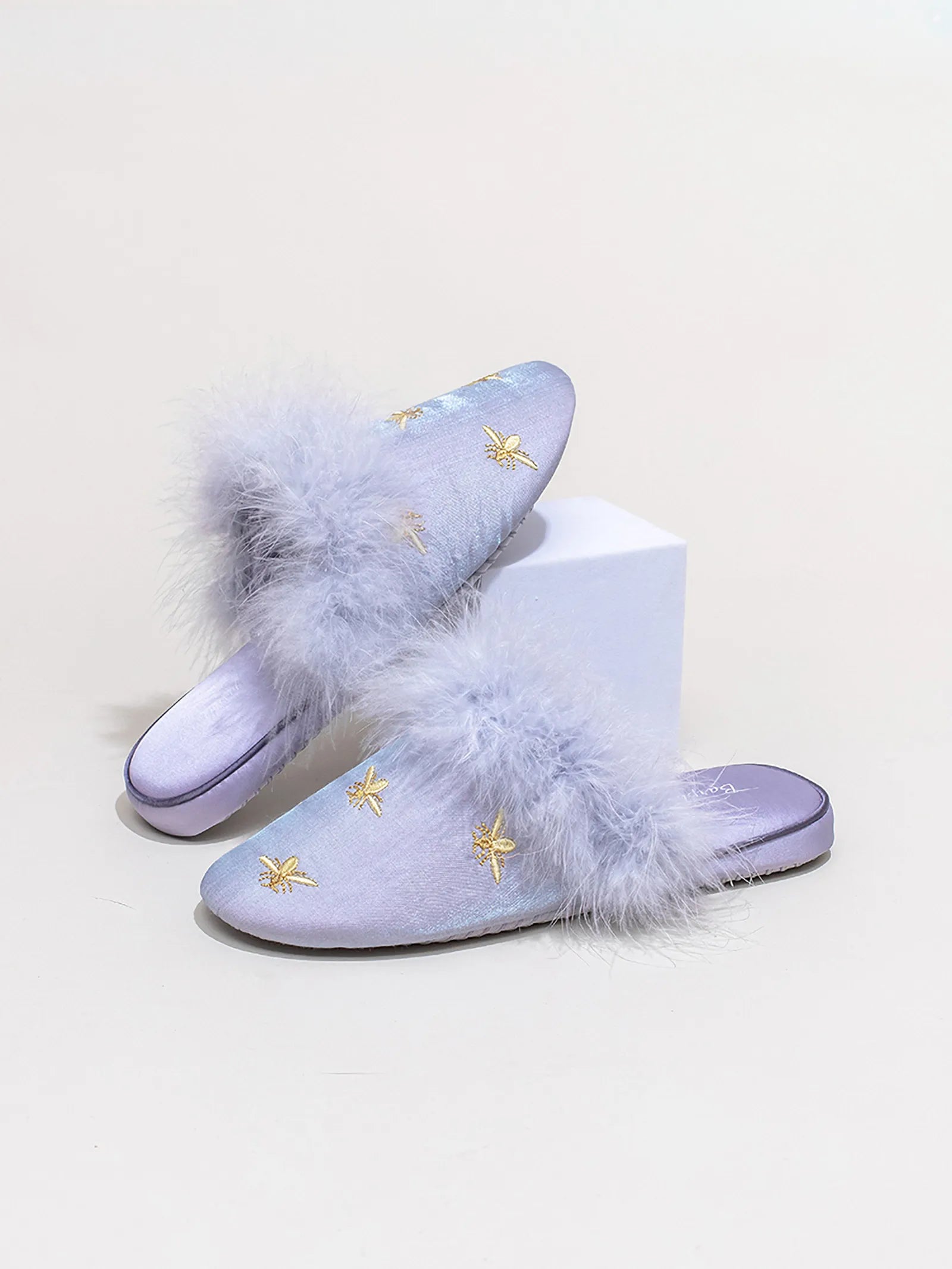 Pair of Purple embroidered bee slippers crossed on a soft rug - RoomDen