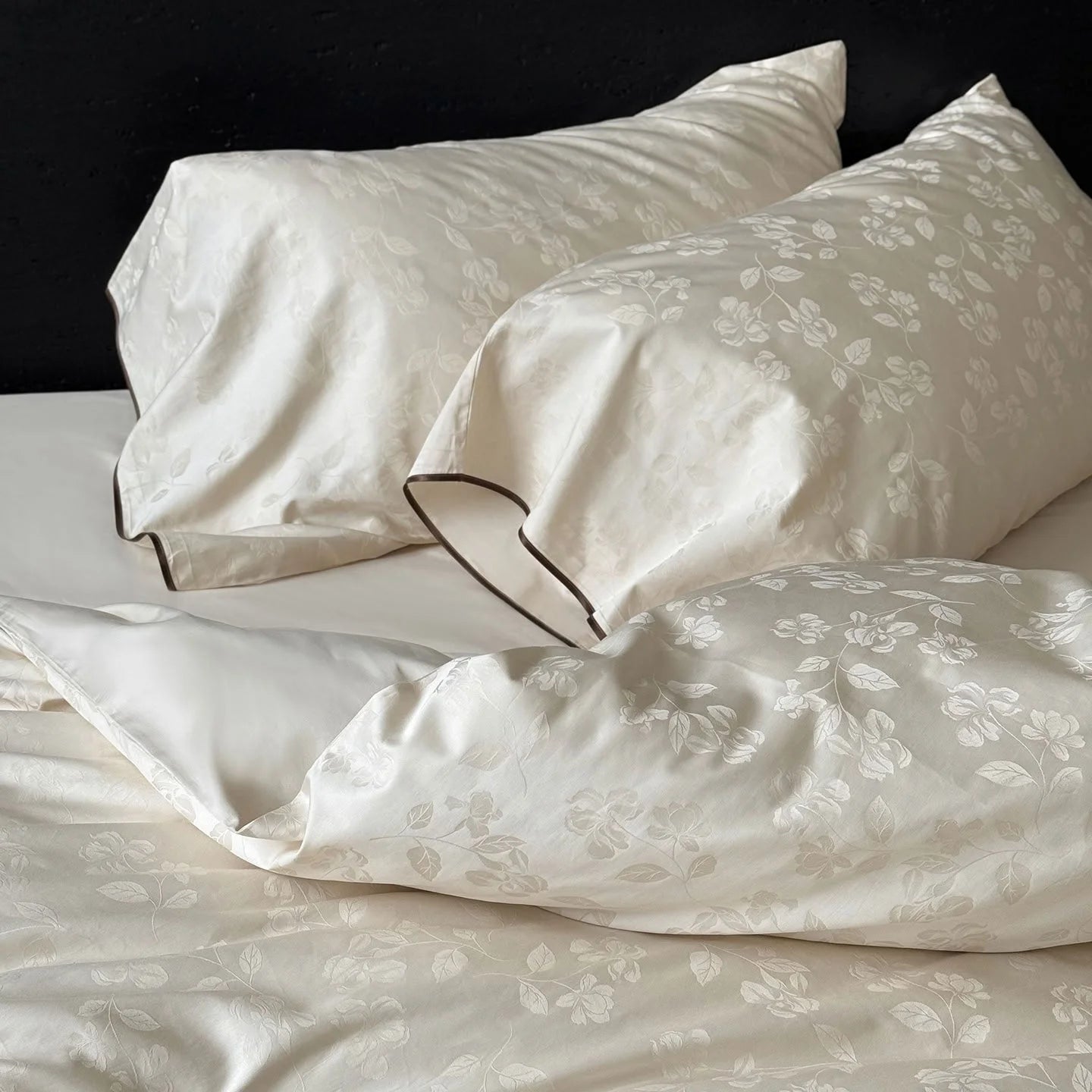 Detail shot of the Pearl White floral jacquard pillowcases, showing the elegant sheen of the Tencel fabric.
