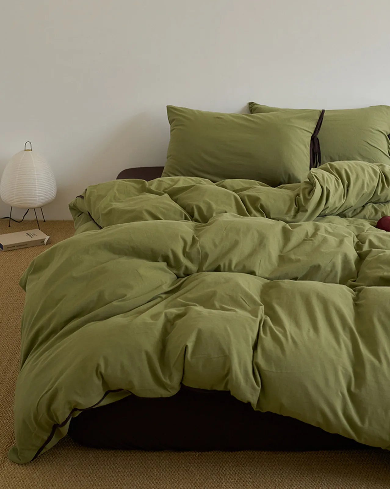 Full view of the cozy Matcha Green & Brown washed cotton bedding set with a paper lantern lamp nearby. - RoomDen