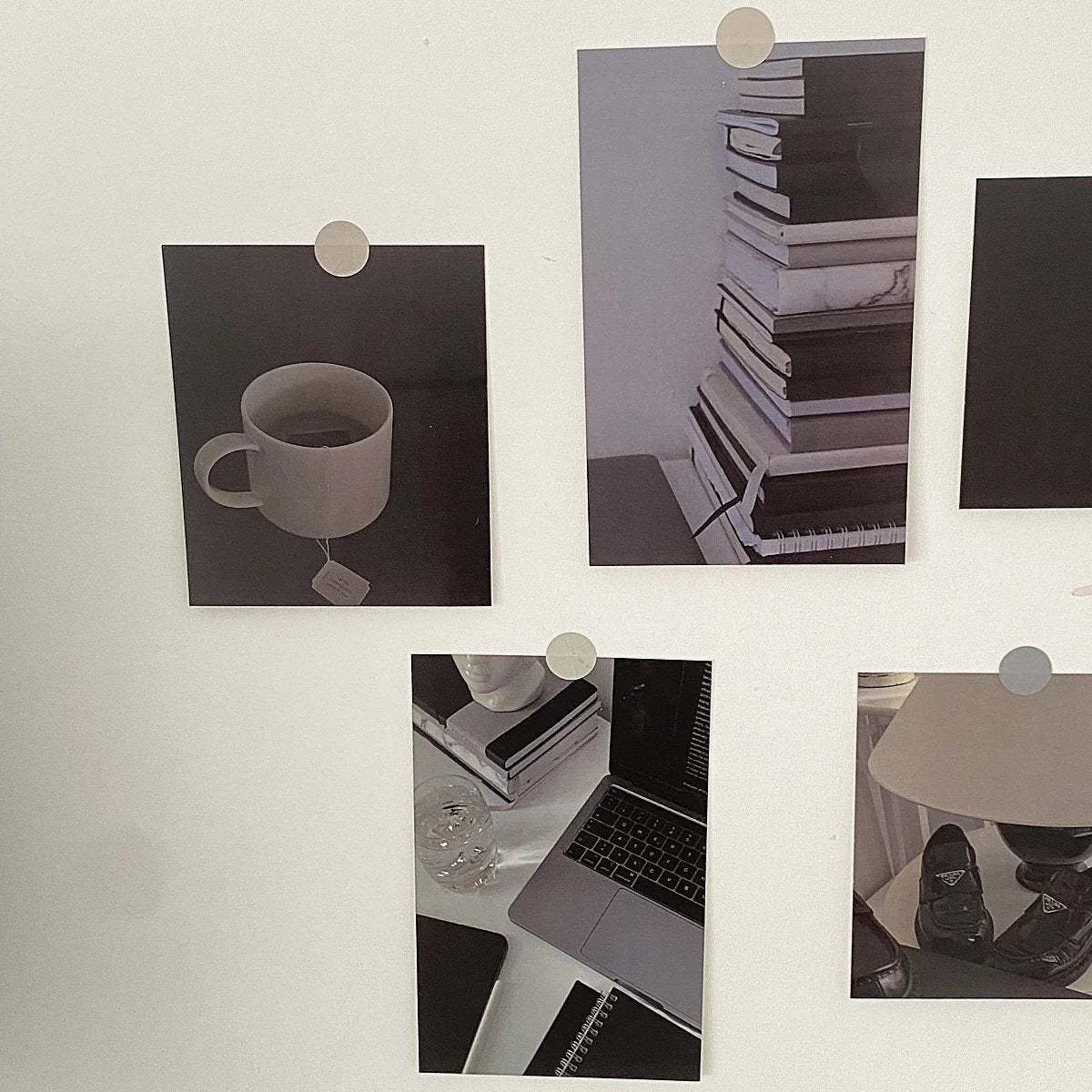 Close-up of the monochrome wall collage cards arranged on a white wall with silver pins. - RoomDen