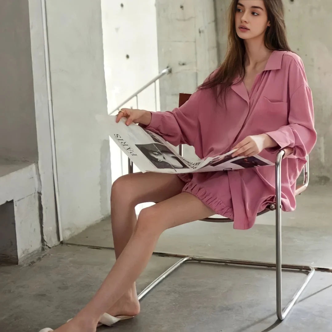A model sitting in a chair reading, demonstrating the comfort and style of the pajama set for lounging. - RoomDen