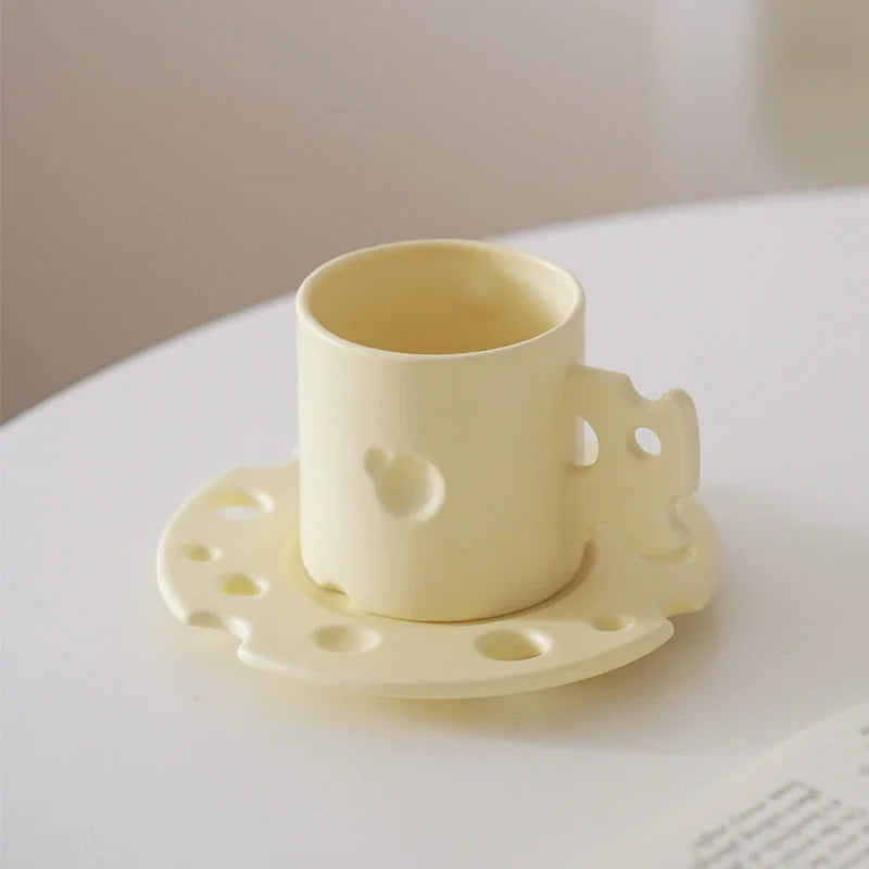 The Cheese Ceramic Mug & Saucer Set in Cheese Yellow on a clean white surface. - RoomDen