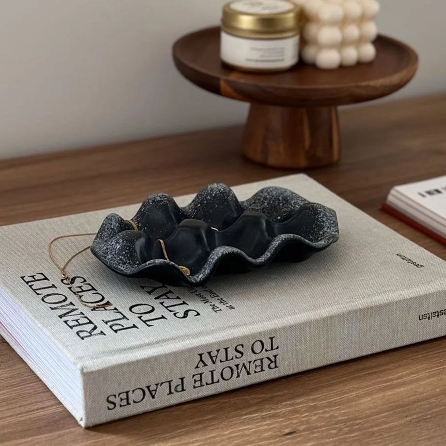 Black Speckled Wavy Ceramic Jewelry Dish displayed on a coffee table book titled "Remote Places to Stay".