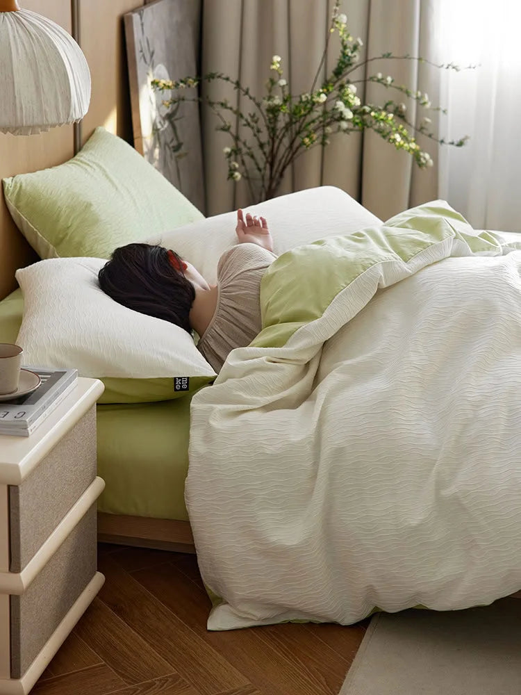 A person sleeping peacefully in the Cream White & Matcha Green Wavy Textured bedding. - RoomDen