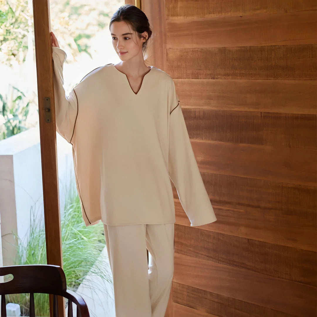 Model in the oversized plush pajama set opening a wooden door to a sunlit patio. - RoomDen