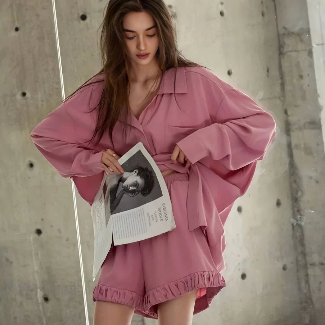 The model holding a magazine, providing a detailed view of the pajama set's texture and fit. - RoomDen