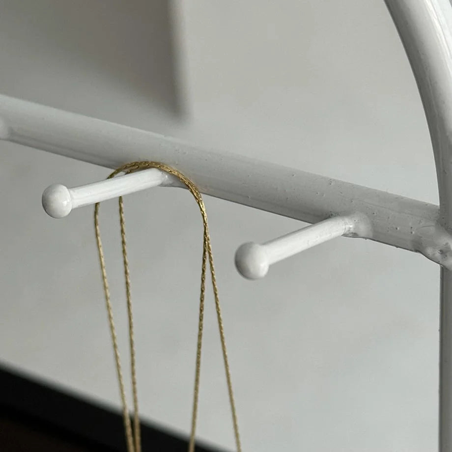 Detail shot of the hooks on the White Arched Metal Jewelry Organizer with a gold chain. - RoomDen