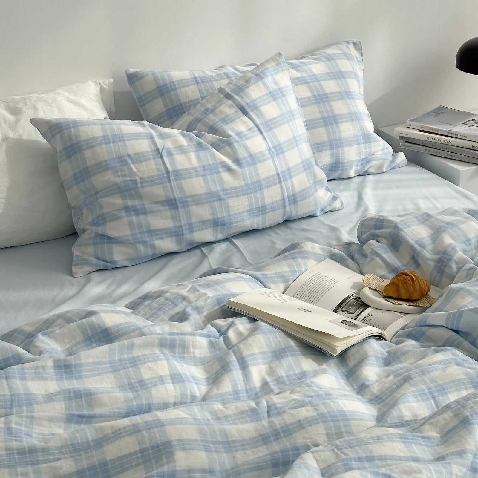 Full view of the Gingham Plaid Washed Cotton Bedding Set styled on a bed next to a stack of books. - RoomDen