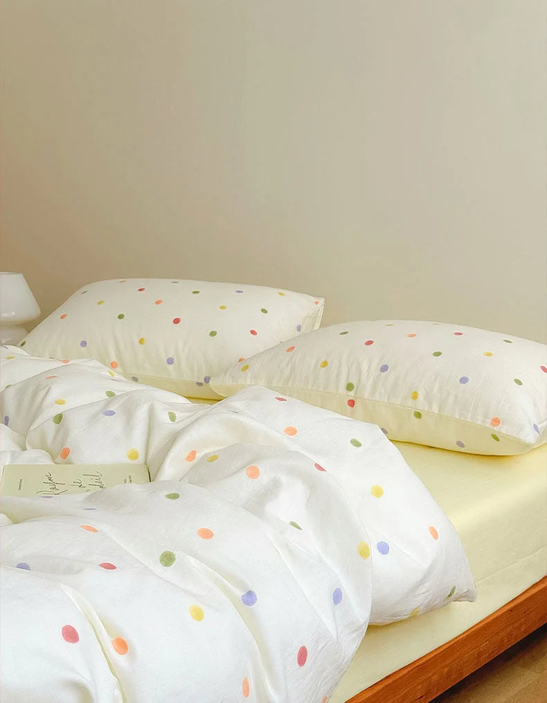 Close-up of the Colorful Polka Dot Washed Cotton Bedding Set with an open book resting on the duvet - RoomDen