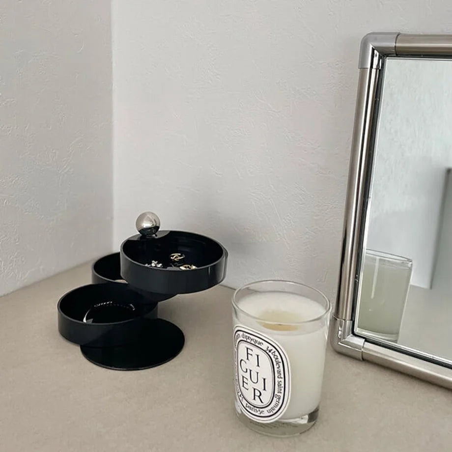 A lifestyle shot of the open Matte Black jewelry organizer on a modern vanity. - RoomDen