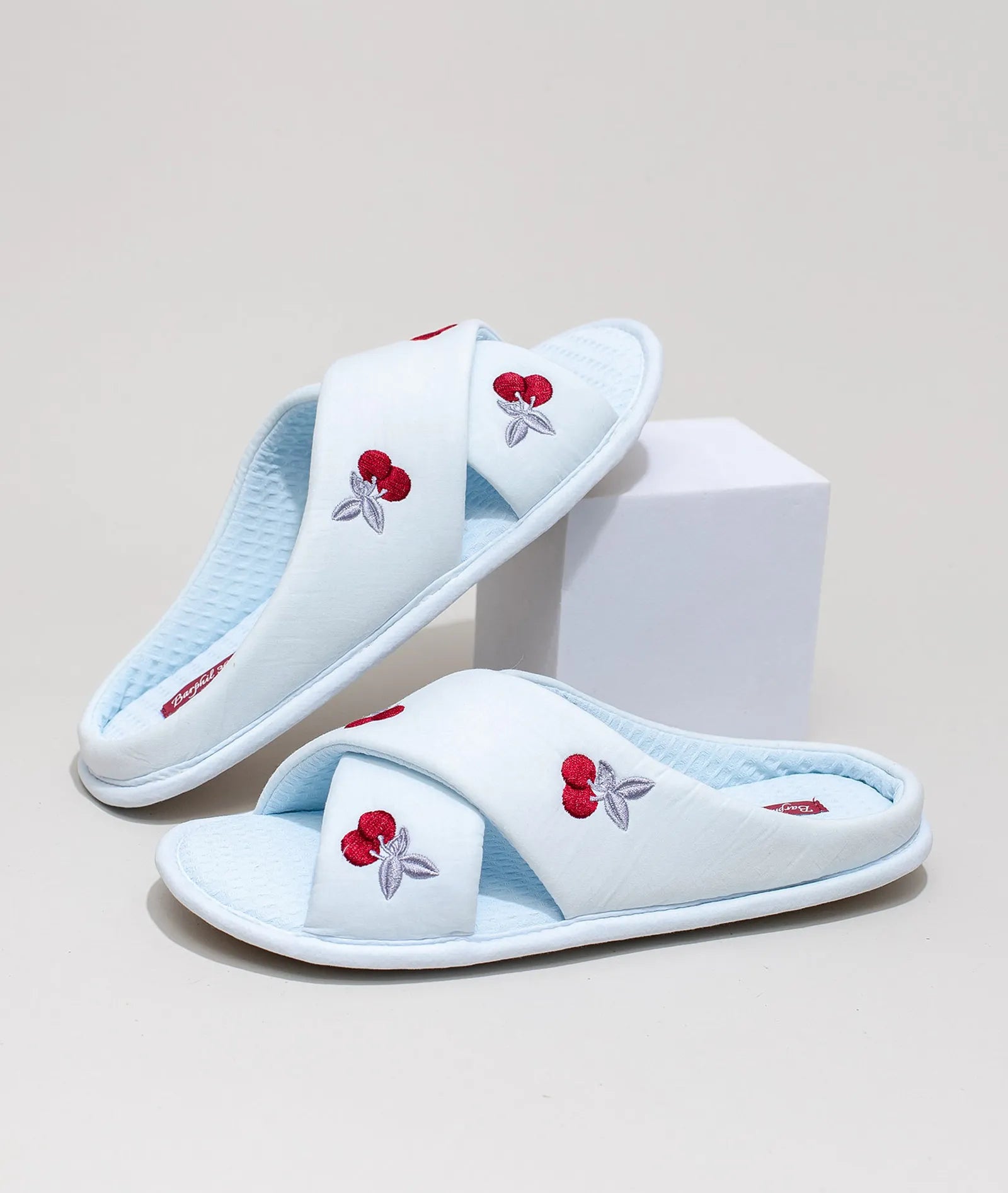 Blue embroidered cherry house slippers on white display block - RoomDen