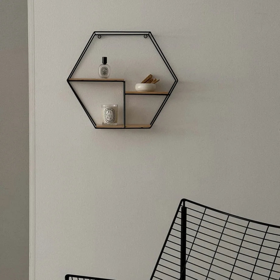 Geometric Hexagon Metal & Wood Wall Shelf in Black, styled with a candle and perfume - RoomDen
