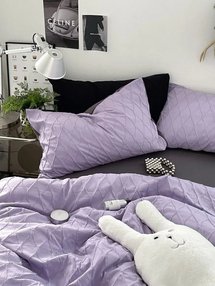 Close-up view of the ruched texture on the lavender washed cotton pillowcases and duvet cover. - RoomDen