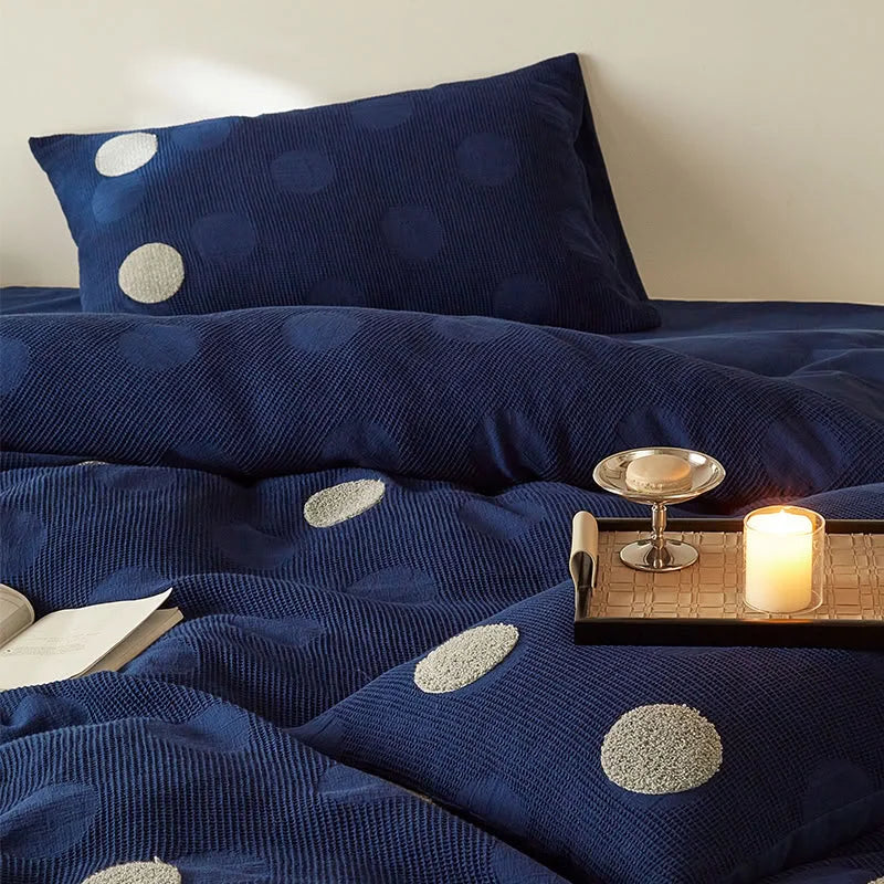 Close-up of the Navy Polka Dot Flannel Fleece Bedding Set, with a candle and tray adding to the cozy ambiance. - RoomDen