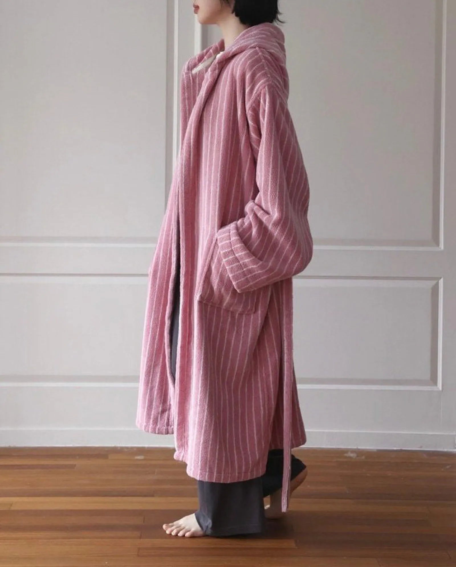 Side profile of a cozy pink striped cotton bathrobe with deep pockets - RoomDen
