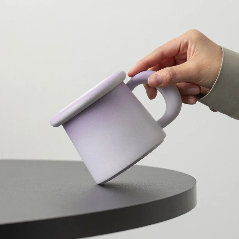 Close-up of a hand holding the Lavender Ombre Frosted Ceramic Mug, showing its matte texture - RoomDen.