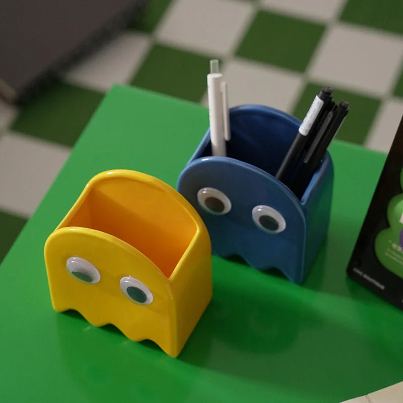 Yellow and blue Retro Ghost Ceramic Pen Holders on a green desk holding pens - RoomDen.