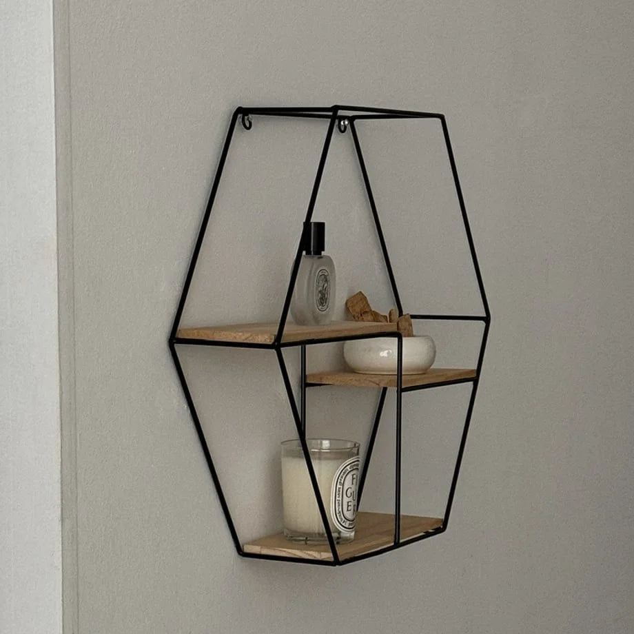 Angled view of the Black Geometric Hexagon Wall Shelf on a neutral wall - RoomDen