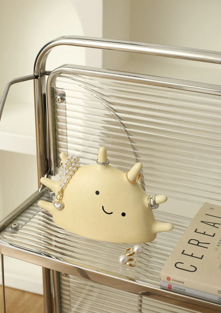 Creamy Beige Smiling Sun Jewelry Organizer styled on a modern glass and chrome shelf with a book - RoomDen