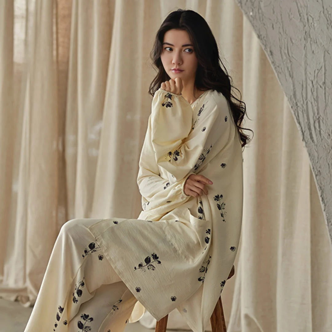 Close-up of model in the botanical print cotton pajama top, looking thoughtfully to the side - RoomDen