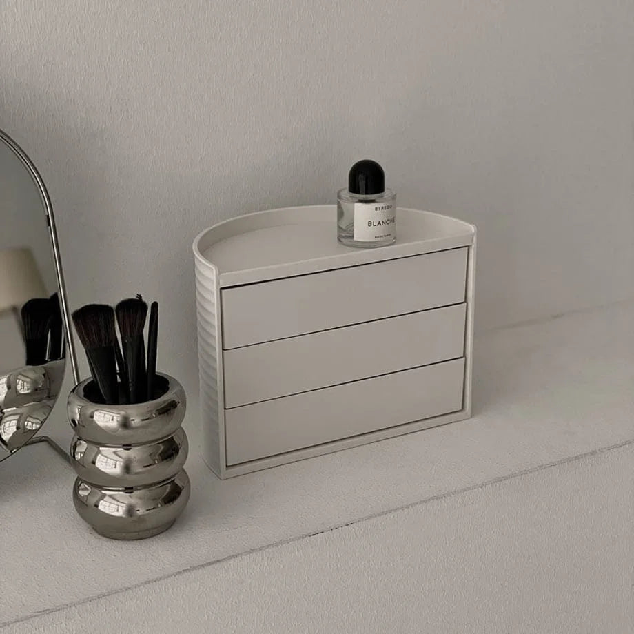 Angled view of the closed cream white makeup organizer, showing its ribbed texture. - RoomDen