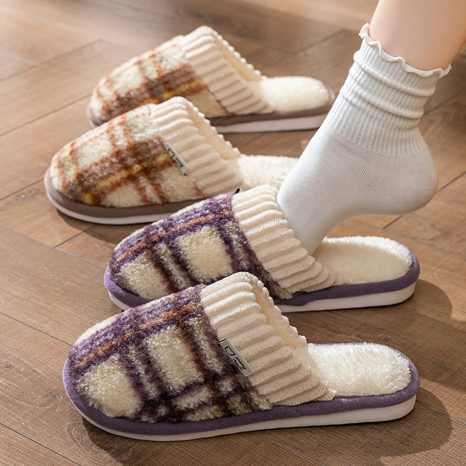 Brown and purple plaid fuzzy slippers displayed on a wooden floor showing side profiles - RoomDen