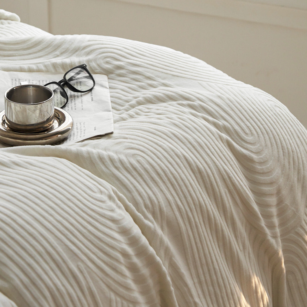 Beige flannel fleece bedding set neatly made on bed, soft textured design - RoomDen