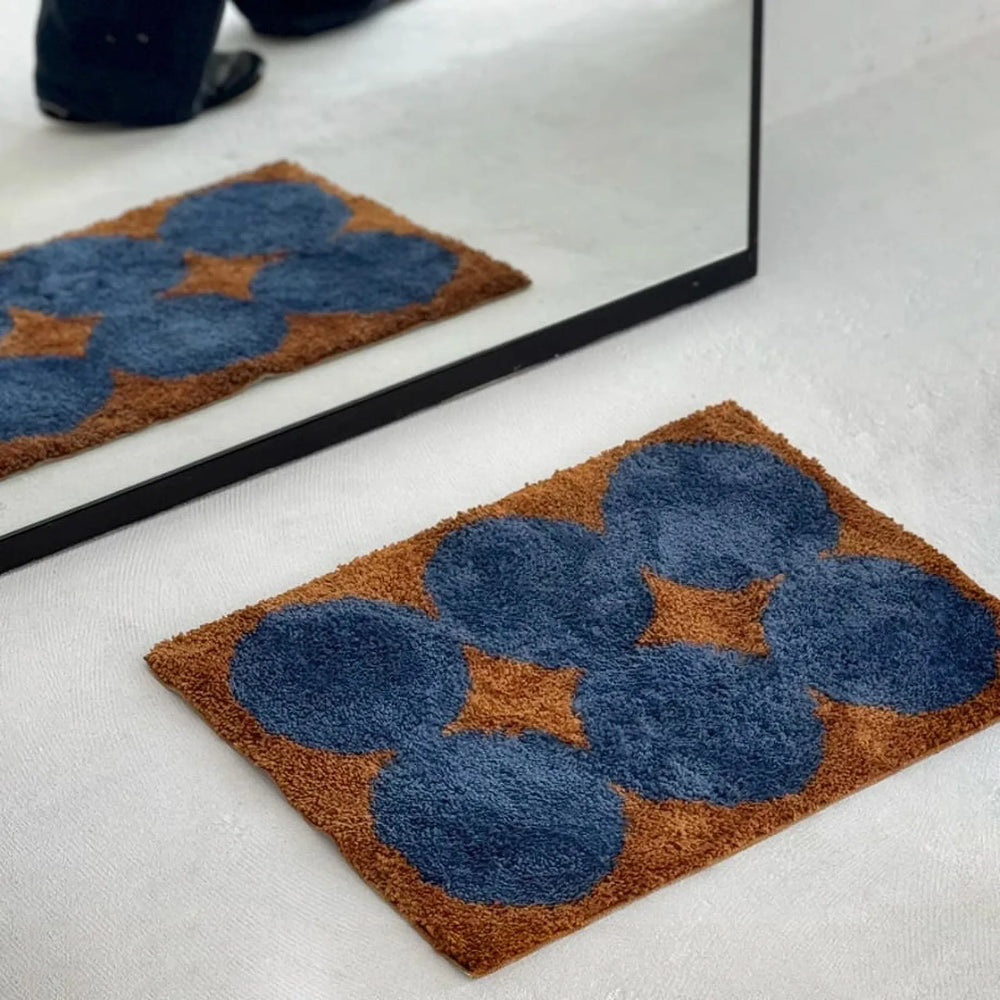 Reflection view in mirror showing the geometric blue and brown rug pattern - RoomDen