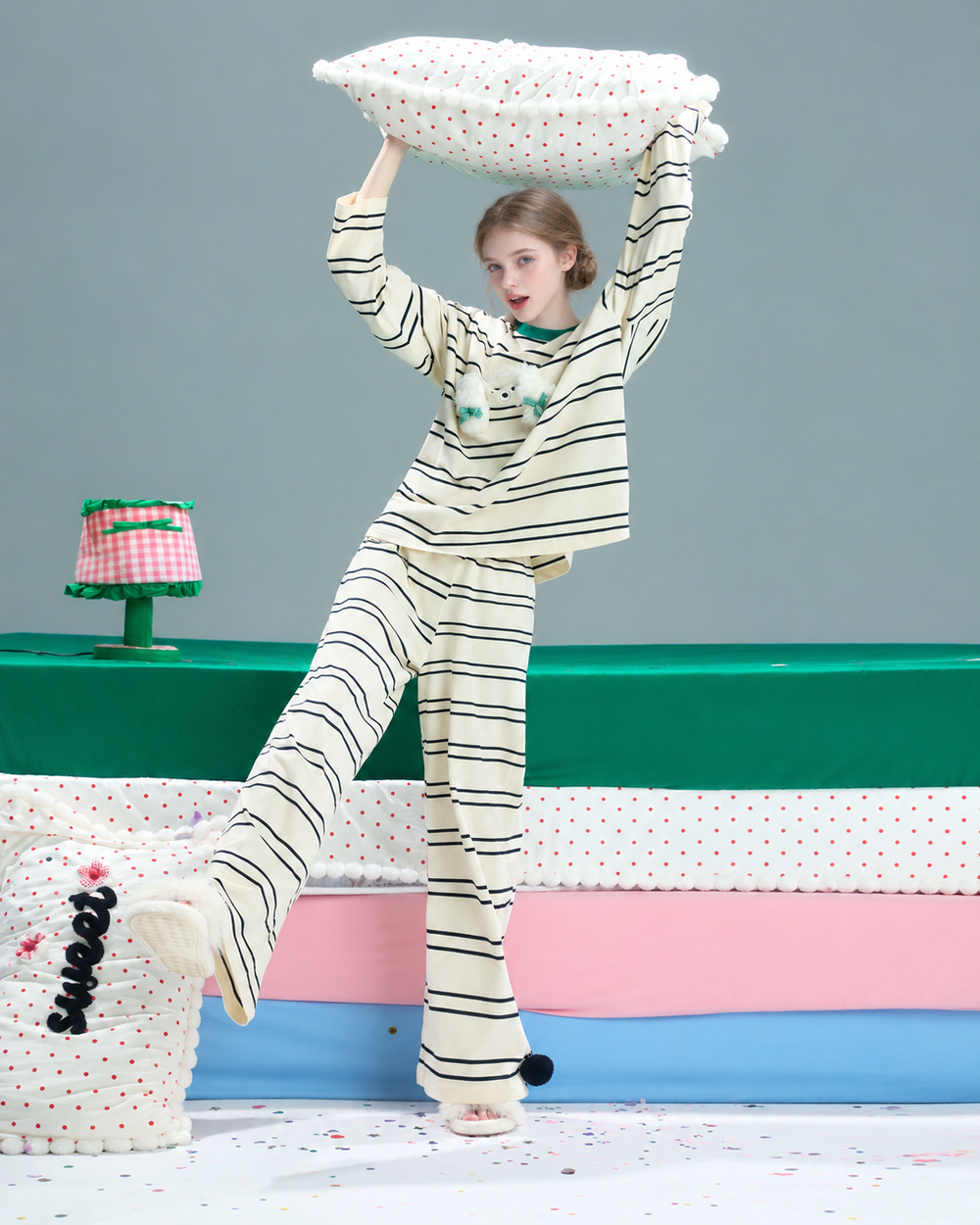 Striped Cat Pajama Set – cream and black stripes with green trim, modeled holding a pillow - Roomden