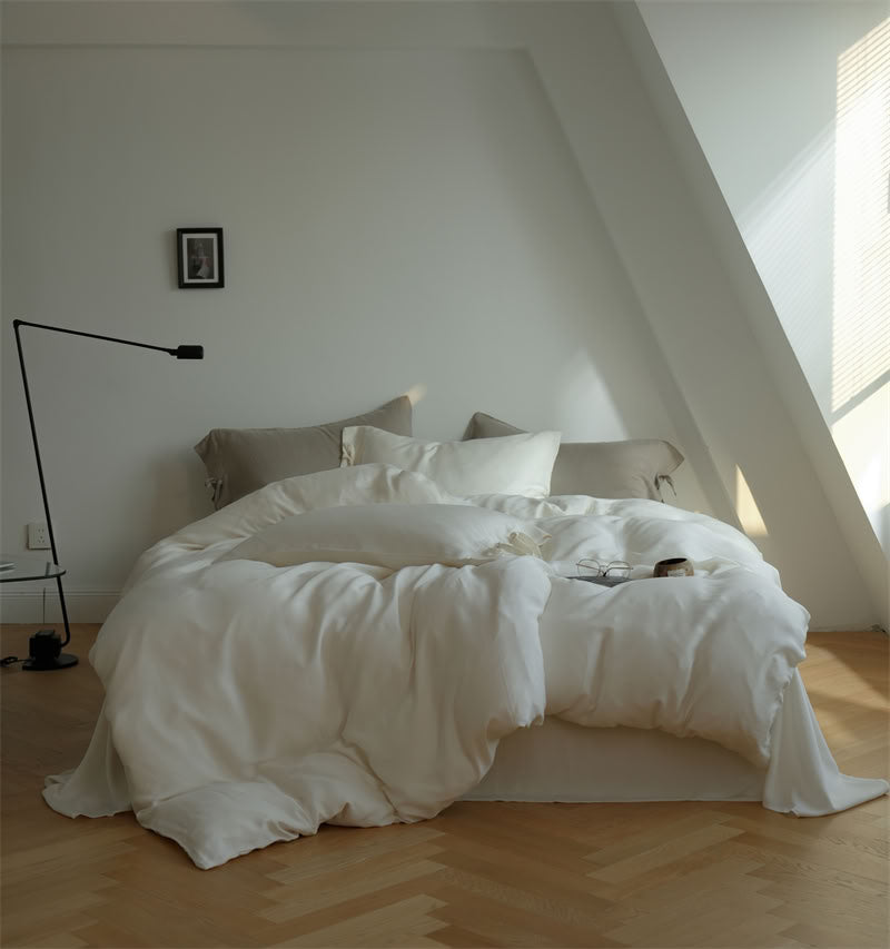 Minimalist bedroom with white Tencel bedding and taupe pillows – RoomDen