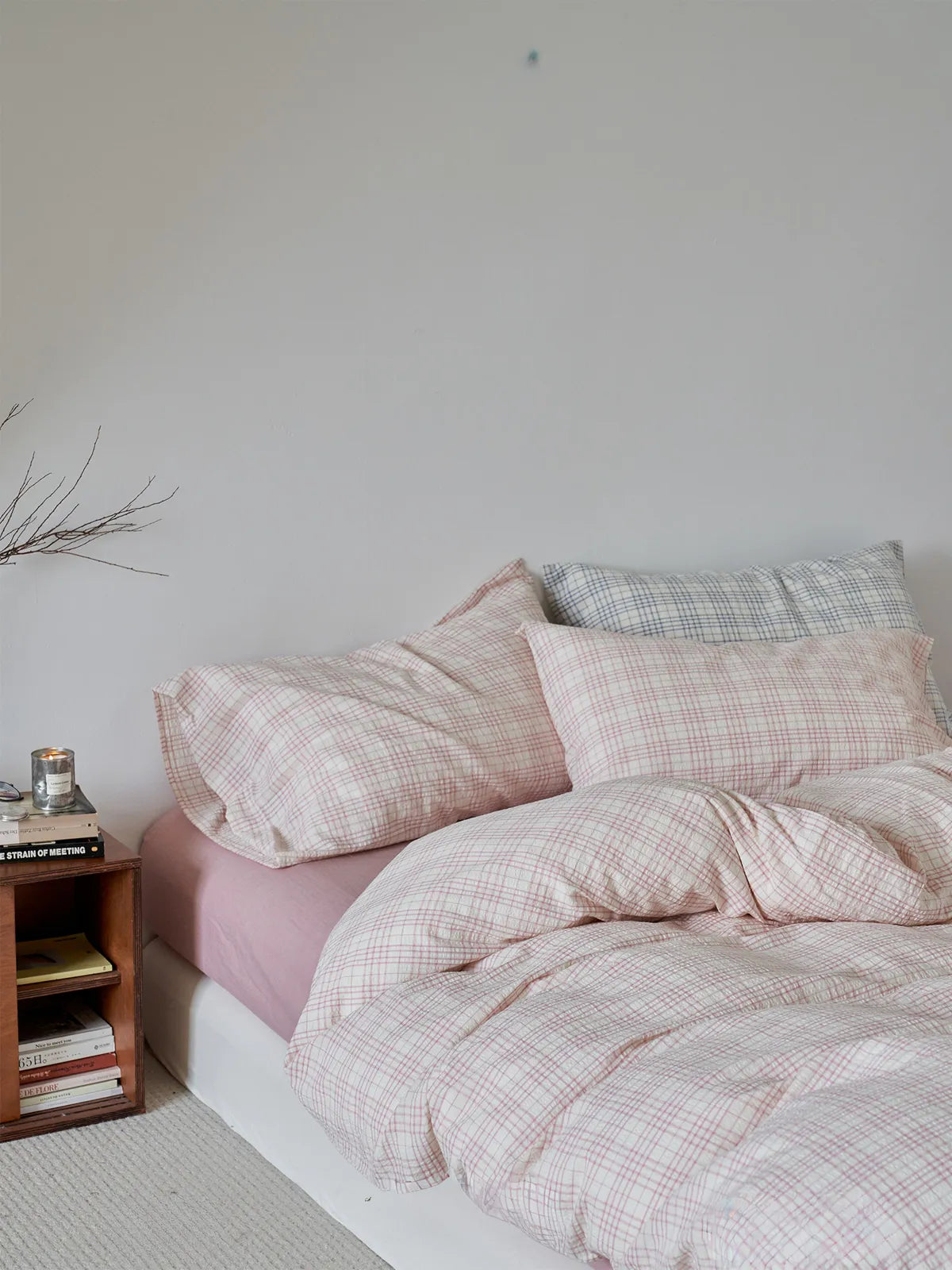 Side view of pink checkered washed cotton duvet cover on wooden bed RoomDen.
