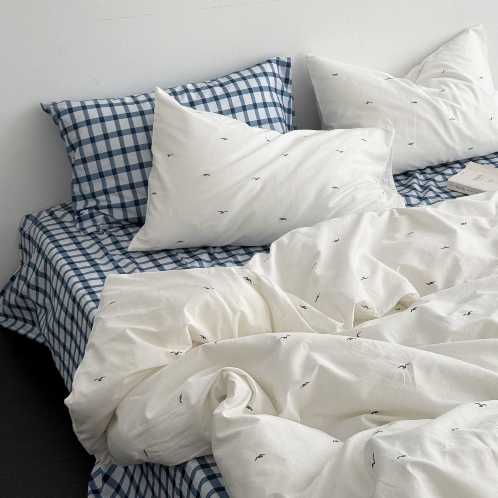 Soft washed cotton duvet cover featuring minimal navy seagull print on white background, full bed view RoomDen