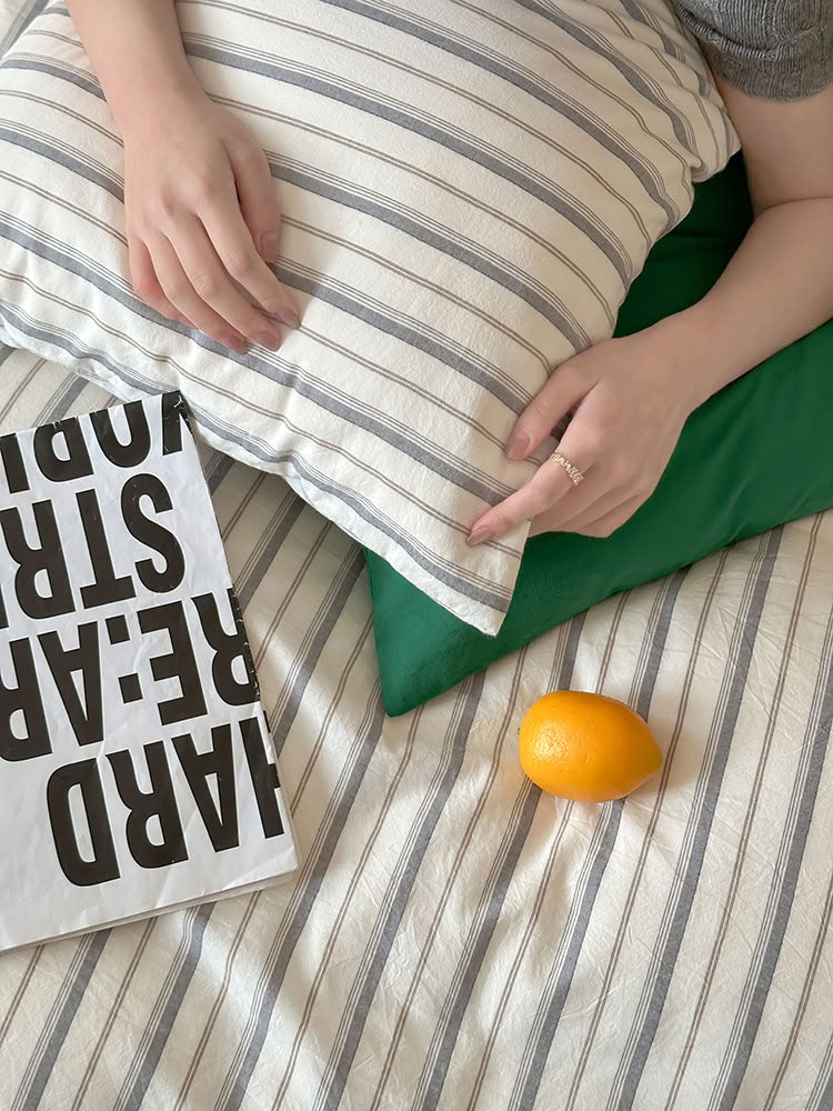 Close-up of soft washed cotton pillowcase showing stripe and solid contrast – RoomDen