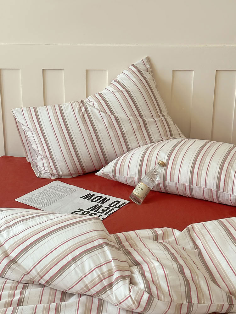 Minimalist bedroom featuring red striped cotton duvet cover and matching solid pillowcases – RoomDen