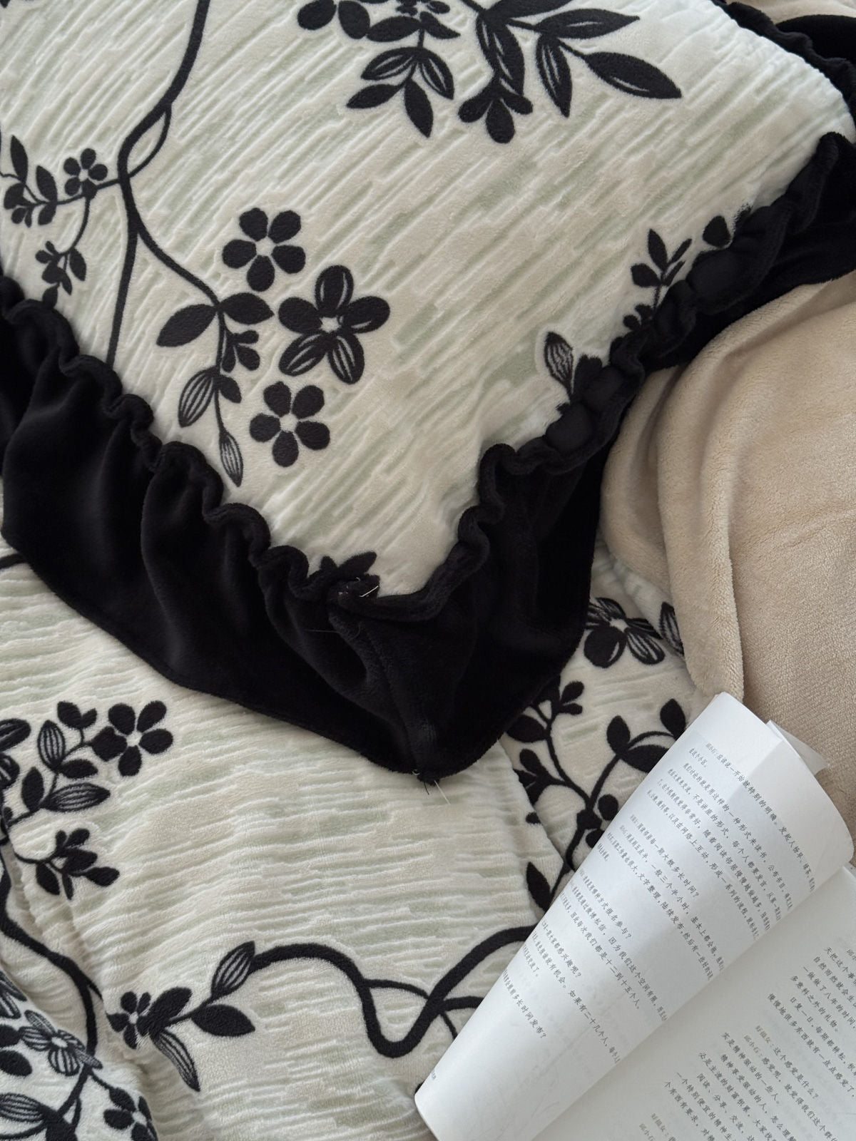 Detail shot of the textured fabric and black velvet-like ruffle trim on the pillow.