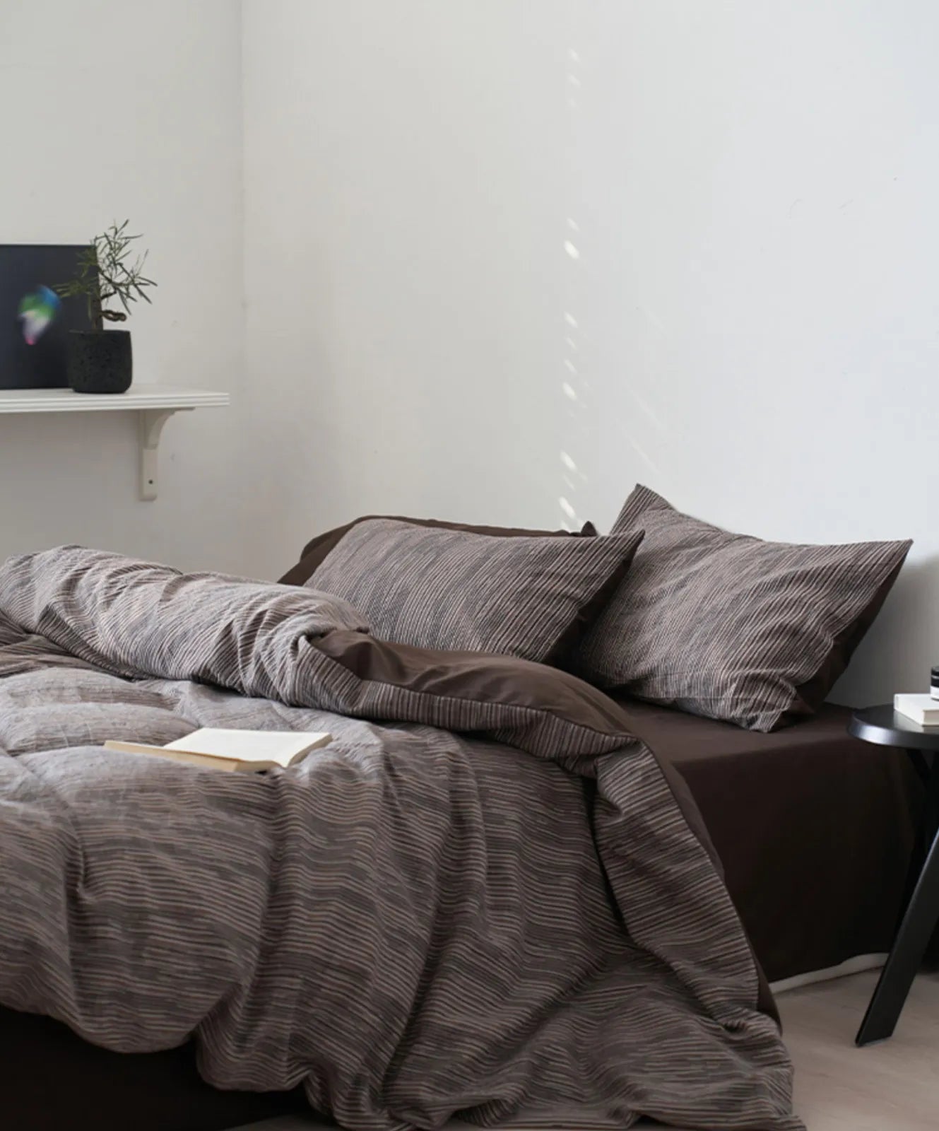Full bed view of charcoal grey minimalist bedding set with side table RoomDen.