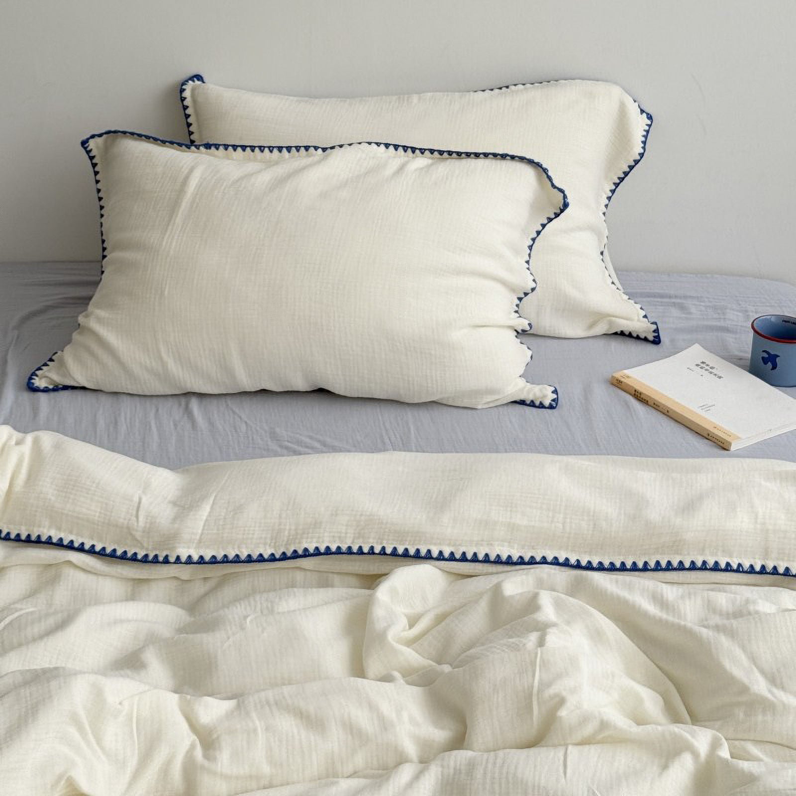 Close up of pillowcase corner with black triangle embroidery | RoomDen