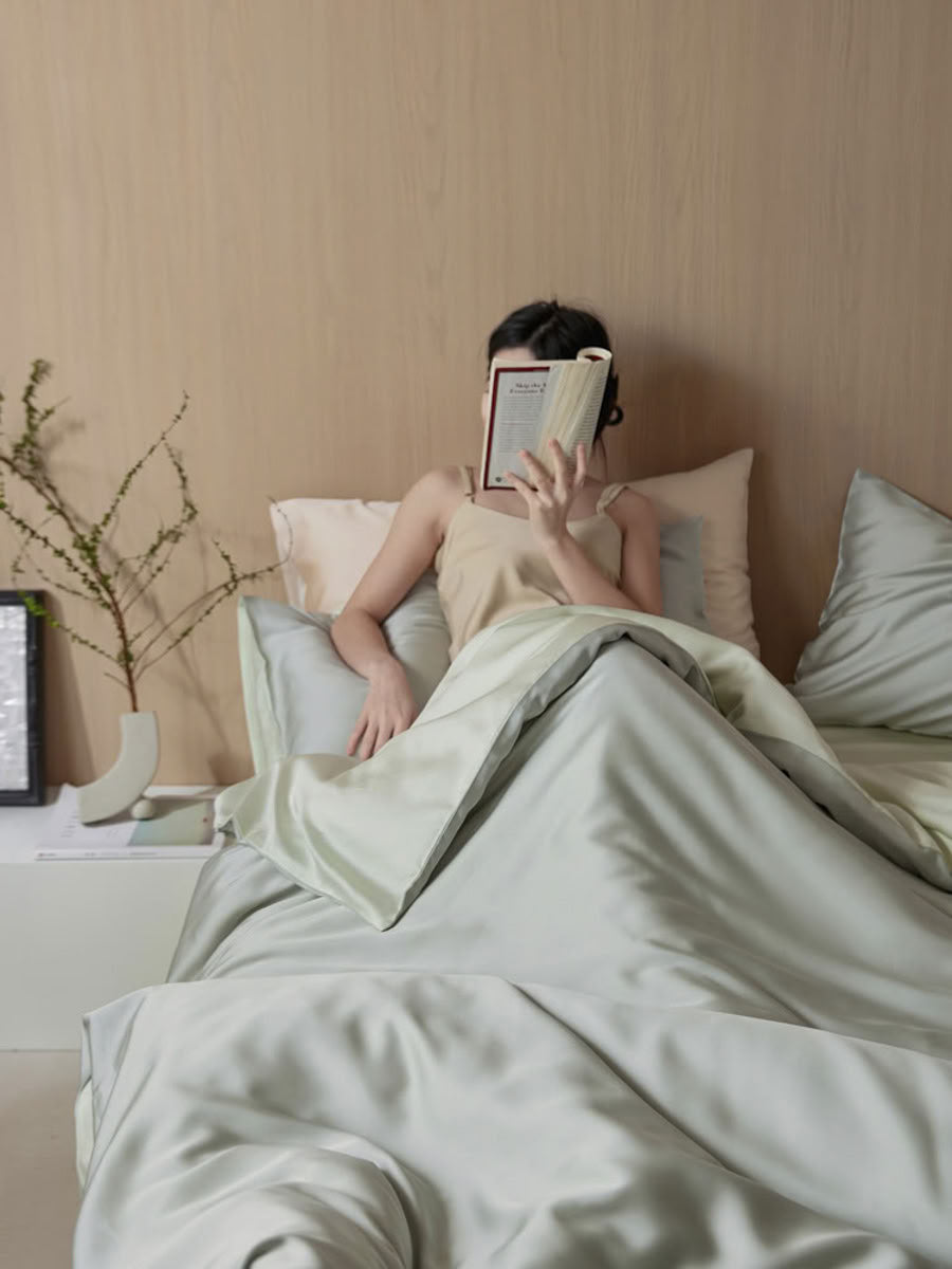 Reading moment in mint green silky bedding, showcasing smooth sheen and calming tone – RoomDen