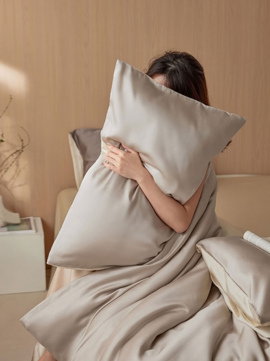 Close-up of woman hugging silky champagne beige pillow in serene bedroom setting – RoomDen