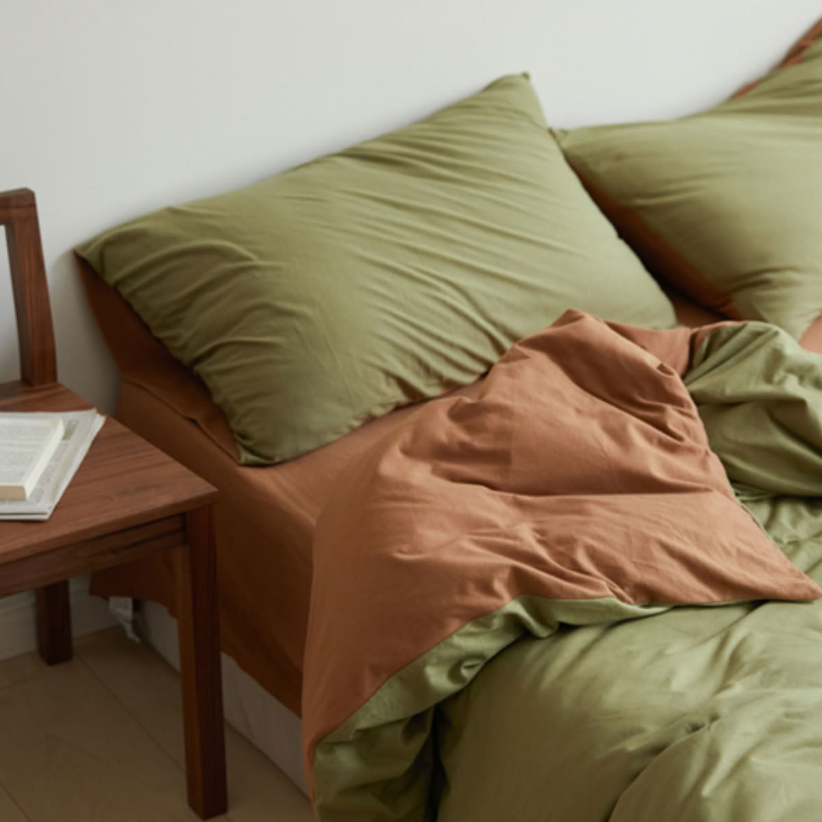 Olive and terracotta two-tone jersey cotton bedding set on bed - RoomDen